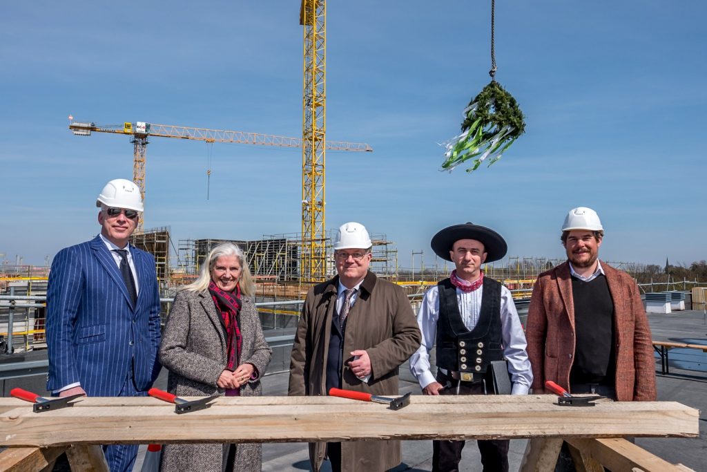 Hammering the nails hard at the topping-out ceremony at Münster University Hospital; with (from left to right) Hospital director Dr. Christoph Hoppenheit, NRW Minister of Science Isabel Pfeiffer-Poensgen, Dean Prof. Frank Ulrich Müller, foreman Urim Rihani and architect Hieronimus Nickl of Nickl & Partner Architekten. Photo: WWU/Thomas Hauss
